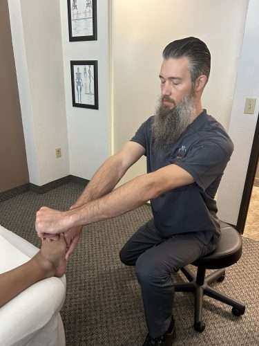 Clinical therapeutic bodywork on foot and calf for ankle pain