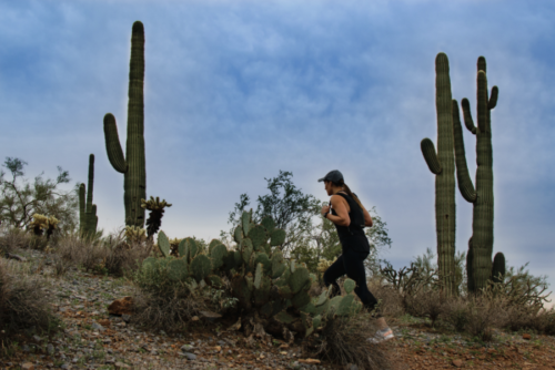 A girl is staying active by hiking in Arizona despite the hot weather by training in the early morning.